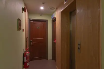 a hallway with a brown door and a fire extinguisher at Hotel Rose Crest Hill, Cameron Highlands in Cameron Highlands