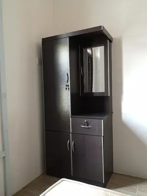 a black cabinet with a mirror and a dresser at Homey Hostel, Ipoh Town in Ipoh