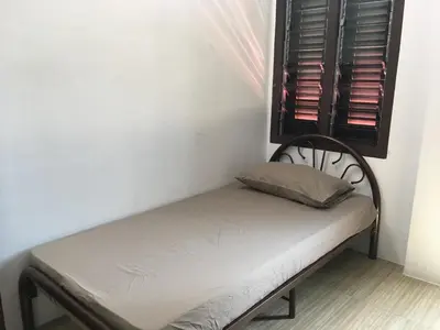 a small bed in a corner of a room at Homey Hostel, Ipoh Town in Ipoh