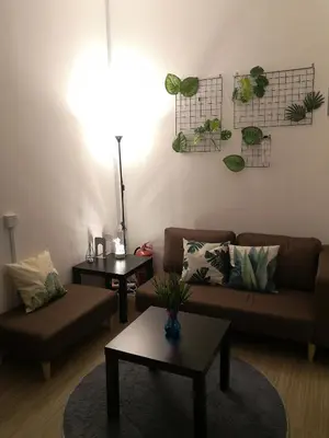 a living room with a couch and two tables at Homey Hostel, Ipoh Town in Ipoh