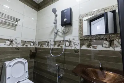 a bathroom with a shower and a toilet and a sink at Lee Luxury Home USM Penang in Gelugor