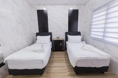 two twin beds in a room with white walls at Lee Luxury Home USM Penang in Gelugor