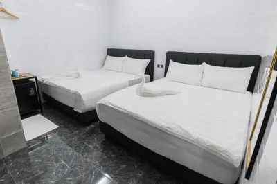 two beds in a room with white sheets at Lee Luxury Home USM Penang in Gelugor