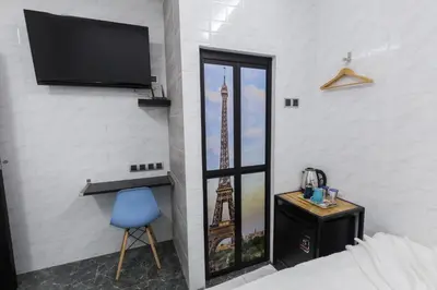 a room with a tv and a bed and a blue chair at Lee Luxury Home USM Penang in Gelugor