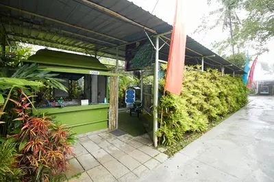 a green kiosk with a black roof and some plants at Bellevue The Penang Hill Hotel, Bukit Bendera in Ayer Itam