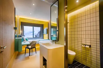 a bathroom with a sink and a toilet and a bedroom at The Upper House, Batu Kawan in Batu Kawan
