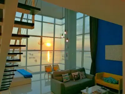 a living room with a couch and a large window at Maritime Suites by Comfy in George Town