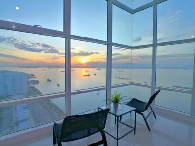 a room with a table and chairs and a view of the ocean at Maritime Suites by Comfy in George Town