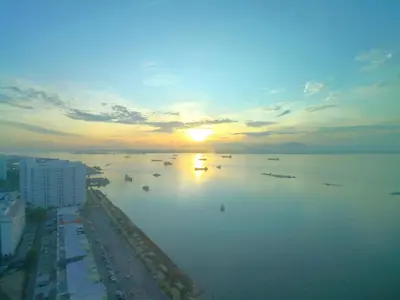 a sunset over a large body of water with boats at Maritime Suites by Comfy in George Town
