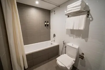 a bathroom with a tub and a toilet and towels at Travelodge Ipoh in Ipoh