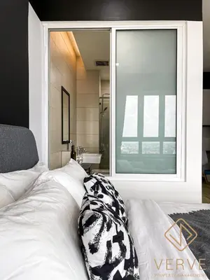 a bed with a pillow on it in front of a window at Ipoh Octagon Premium Suites by Verve in Ipoh