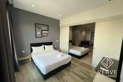 a hotel room with two beds and a mirror at Ipoh Octagon Premium Suites by Verve in Ipoh