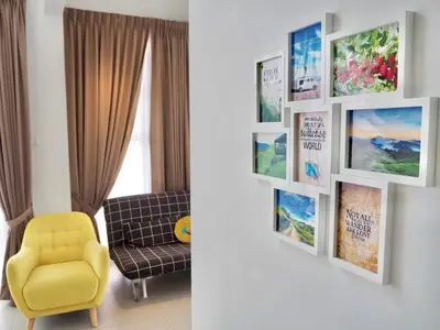 a living room with a yellow chair and pictures on a wall at The PENT Duplex Cameron in Tanah Rata