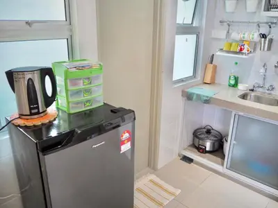 a small kitchen with a refrigerator and a sink at The PENT Duplex Cameron in Tanah Rata