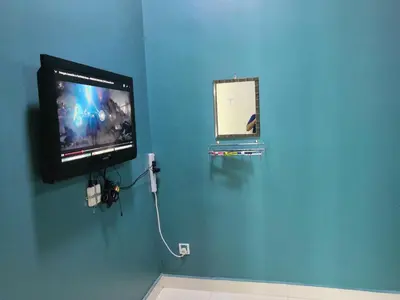 a tv on a blue wall with a video game at WeJDAN INN BALIK PULAU, PENANG ISLAND in Balik Pulau