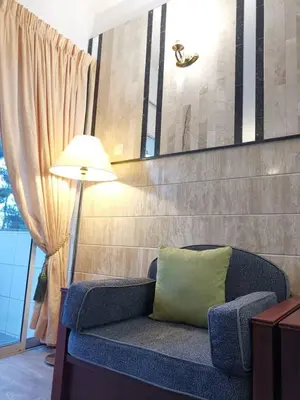 a blue couch with a green pillow next to a lamp at Hills Sanctuary Retreat, B7-3A-2 with WI-FI in Bukit Fraser
