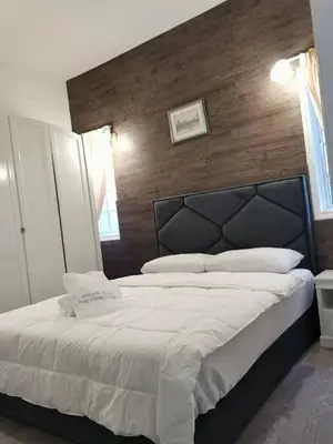 a bedroom with a large bed with a wooden wall at Hills Sanctuary Retreat, B7-3A-2 with WI-FI in Bukit Fraser