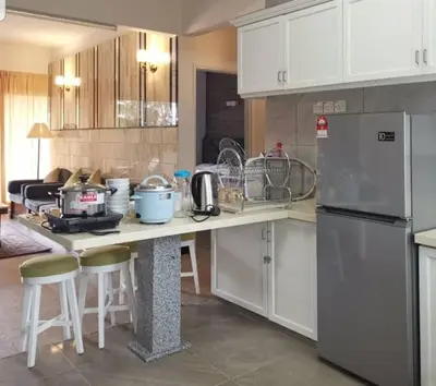 a kitchen with white cabinets and a counter with a refrigerator at Hills Sanctuary Retreat, B7-3A-2 with WI-FI in Bukit Fraser