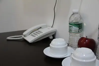 a phone and an apple and a bottle of water at Big Apple Hotel in Kulim