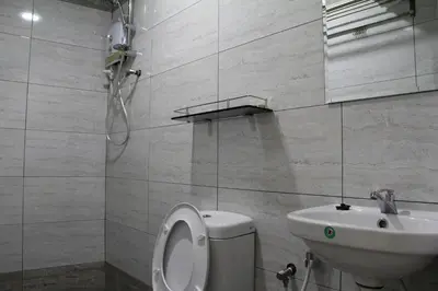 a bathroom with a toilet and a sink at Big Apple Hotel in Kulim