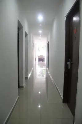 a hallway with white walls and a door to a room at Big Apple Hotel in Kulim