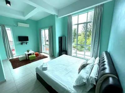 a blue bedroom with a bed and a couch at OK FAMILY VILLA in Ipoh