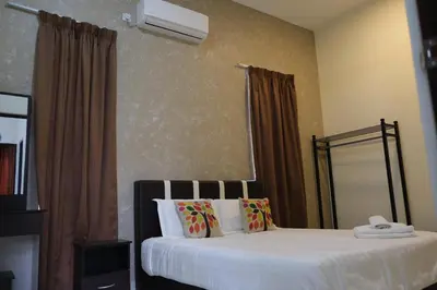 a bedroom with a large bed with white sheets and pillows at OK FAMILY VILLA in Ipoh