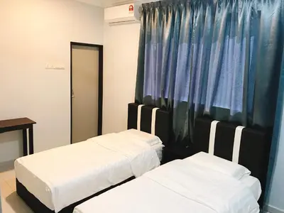 two beds in a room with a curtain at OK FAMILY VILLA in Ipoh