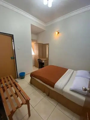 a bedroom with a bed and a chair in it at HILLVIEW HOMESTAY in Tanah Rata