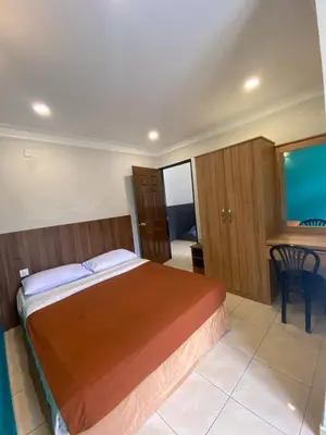 a bedroom with a bed and a desk and a table at HILLVIEW HOMESTAY in Tanah Rata