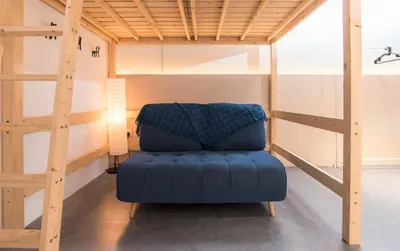 a blue couch sitting under a bunk bed at Abu Siti George Town in George Town