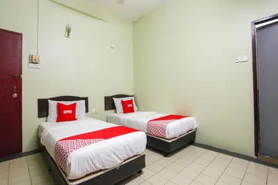two beds in a room with red pillows on them at OYO 89549 Casavilla Hotel (city Centre) Taiping in Taiping