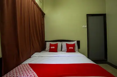 a bedroom with a bed with two red pillows at OYO 89549 Casavilla Hotel (city Centre) Taiping in Taiping