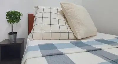 a bed with two pillows and a plant on it at Ipoh Meru Casa Kayangan by BeeStay in Ipoh