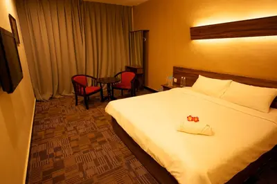 a hotel room with a bed and a table and chairs at De Botani Hotel in Ipoh