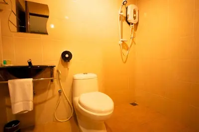 a bathroom with a toilet and a phone on the wall at De Botani Hotel in Ipoh