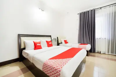 a bedroom with two beds with red pillows at Hotel O Kulim Inn in Kulim