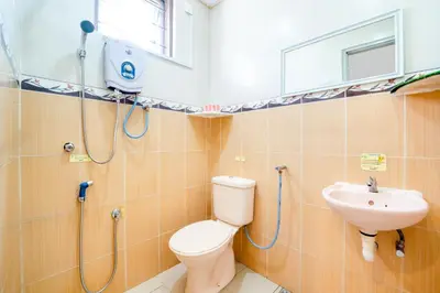 a bathroom with a toilet and a sink at Hotel O Kulim Inn in Kulim