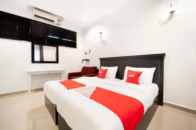 a bedroom with a large bed with red pillows at Hotel O Kulim Inn in Kulim