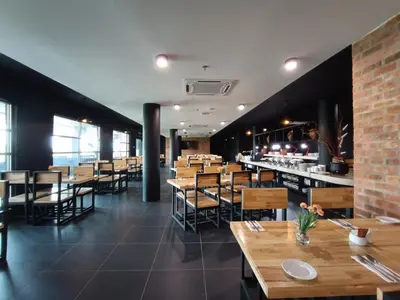 a dining room with wooden tables and chairs at Raia Inn Penang in Bayan Lepas
