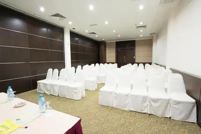 a row of white chairs in a conference room at Raia Inn Penang in Bayan Lepas