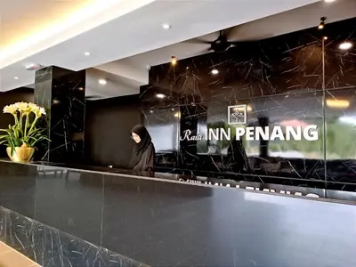 a woman sitting at a counter in a restaurant at Raia Inn Penang in Bayan Lepas