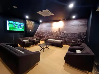 a living room with couches and a large screen at Raia Inn Penang in Bayan Lepas