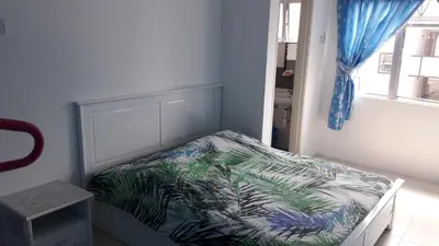 a small bedroom with a bed with a blue curtain at The Sky - The Cave Guest House in Tanah Rata