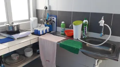 a kitchen counter with a sink and a towel at The Sky - The Cave Guest House in Tanah Rata