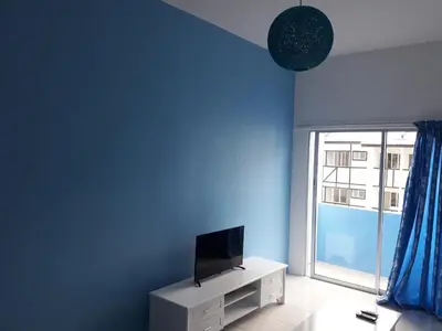 a blue room with a tv and a window at The Sky - The Cave Guest House in Tanah Rata