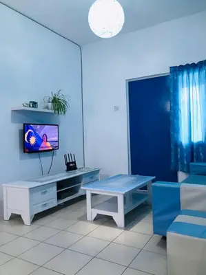 a living room with a tv and a bench at The Cave - Adults Only in Tanah Rata