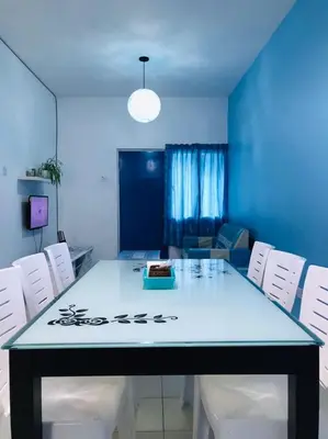 a dining room with a table and white chairs at The Cave - Adults Only in Tanah Rata
