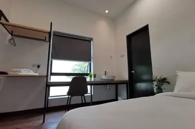 a bedroom with a bed and a desk with a chair at Mary's Residence Ipoh in Ipoh