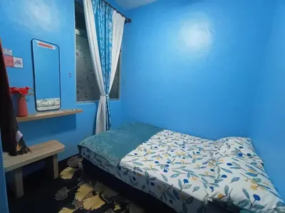a blue bedroom with a bed and a window at The Handz House II with WIFI - For family or same gender only in Kepala Batas